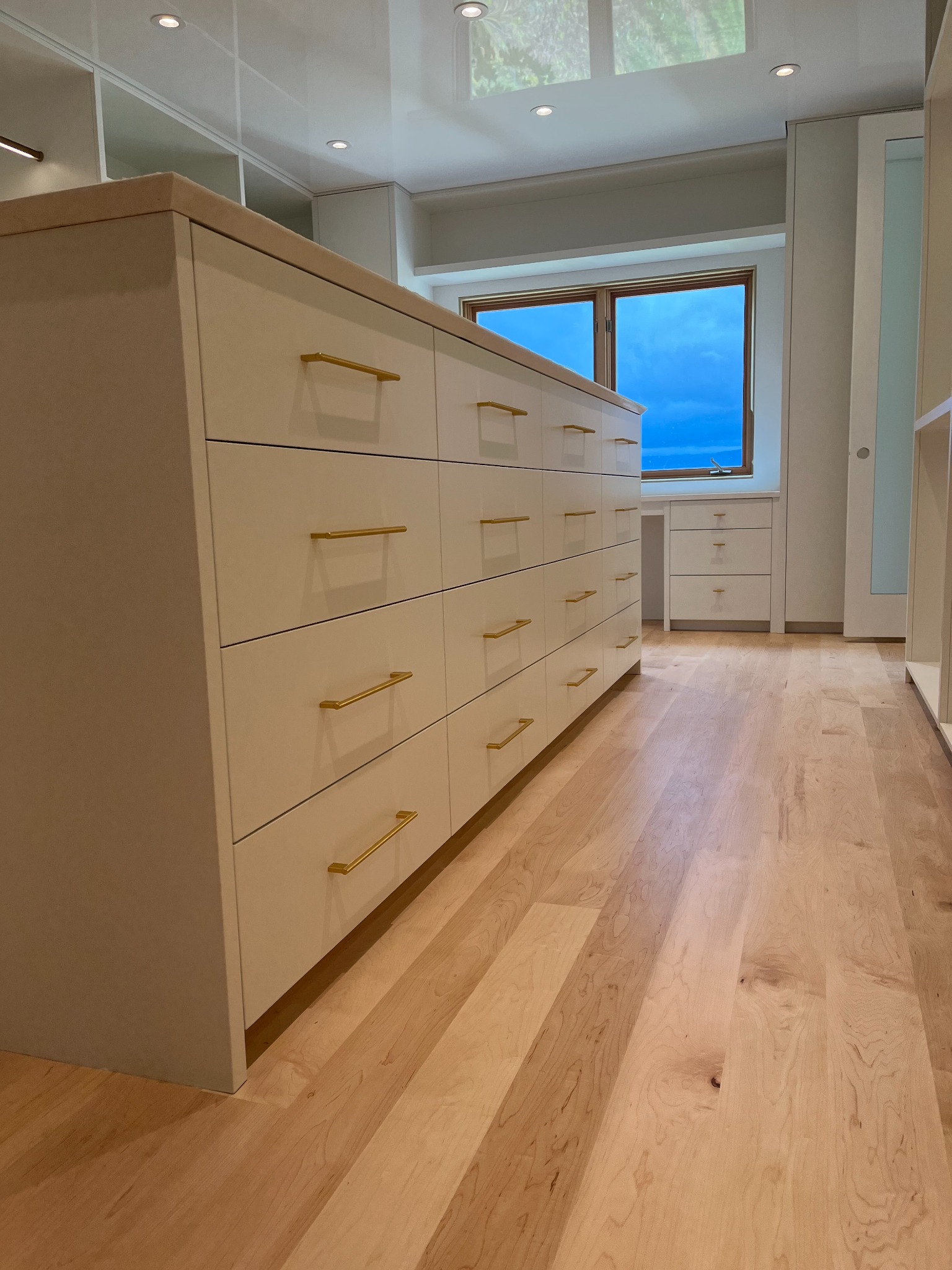 White dressing room island with multiple drawers and brass pulls