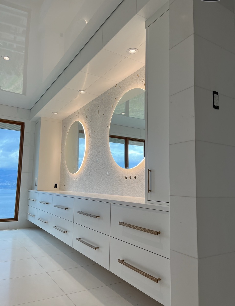 Floating white double vanity with two illuminated round mirrors