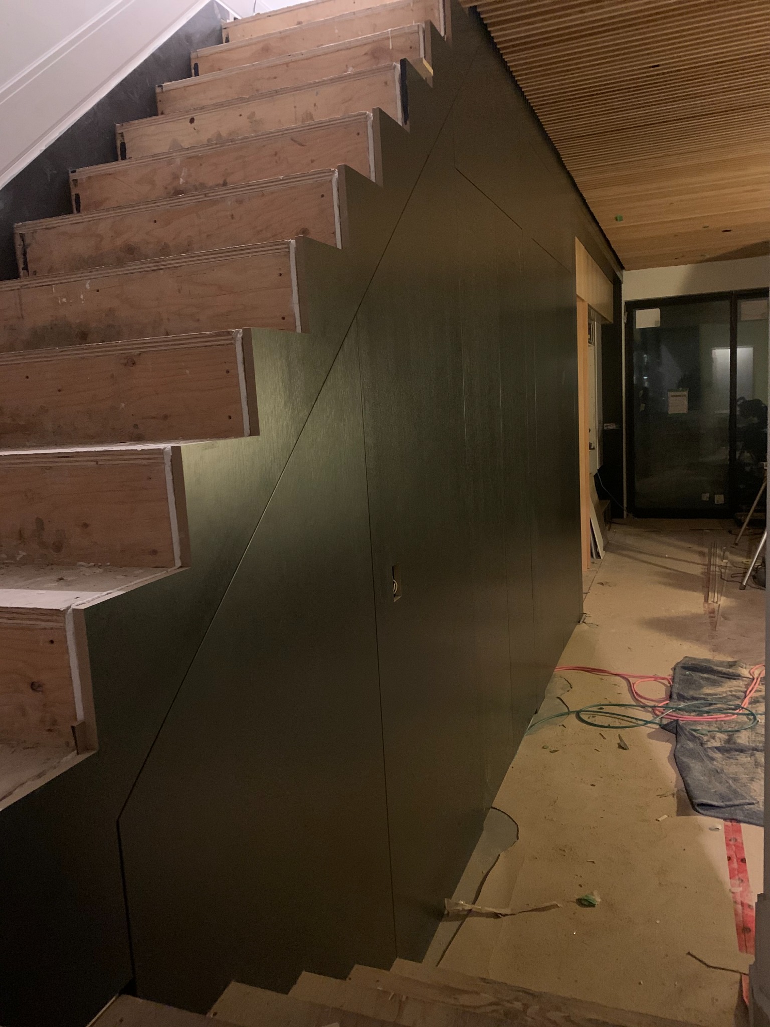 Close view of dark stair-wall cladding fitted to the staircase profile